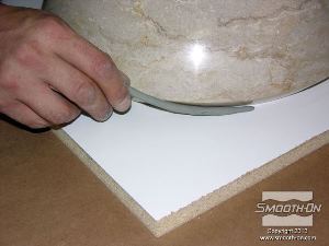 לחיצה להגדלת תמונה אוטמים את התפר בין הכיור ללוח הבסיס בעזרת חימר נטול גופרית.