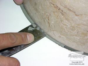 לחיצה להגדלת תמונה ממלאים את הרווח בין הספייסר לכיור בעזרת חימר נטול גופרית.