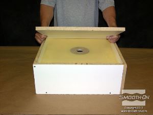 לחיצה להגדלת תמונה סוגרים את מסגרת התבנית בלוח בסיס עליון, בזמן שהפוליאוריטן VytaFlex® 40 מתמצק.