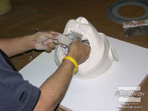 לחיצה להגדלת תמונה מניחים את המודל על לוח בסיס ממלאמין וממלאים את חלל הפה שלו בעזרת החימר, עד לגב המודל כך שלא ישארו בו חללים.