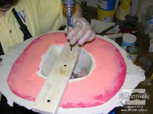 לחיצה להגדלת תמונה קודחים ברגים ומקבעים קרש עץ שטוח לאורך התבנית כדי להקל על חליצת הפקק בהמשך.