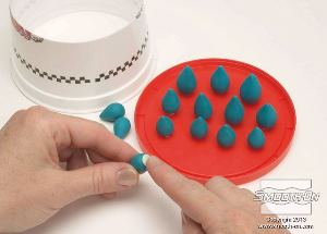 לחיצה להגדלת תמונה מדביקים את חתיכות החימר לתחתית מיכל.