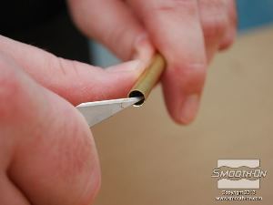 לחיצה להגדלת תמונה בעזרת סכין, משחיזים בזהירות קצה אחד של צינור פליז.