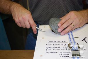 לחיצה להגדלת תמונה לאחר ההתמצקות חותכים את עודפי החומר שיצאו מחורי המכסה.