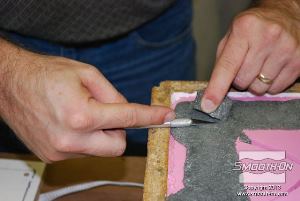 לחיצה להגדלת תמונה חותכים את שאריות החומר של תעלות כניסת החומר והאוורור שנשארו מהיציקה.