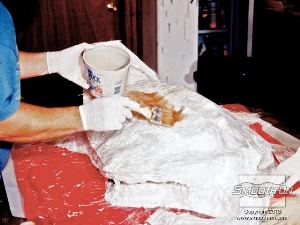 לחיצה להגדלת תמונה מורחים שכבה ראשונה של כ40 גרם סיבי זכוכית ומספיגים ב אפוקסי להספגת בדים. עושים ליי-אפ (lay-Up) בעזרת מברשת כדי להוציא בועות אוויר מהחומר.