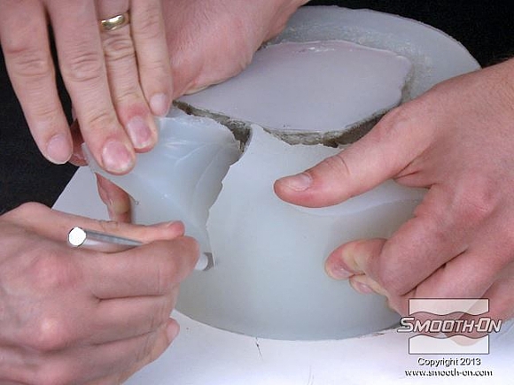 לחיצה להגדלת תמונה אזהרה: בשלב הבא משתמשים בסכין חד, לחיתוך התבנית ויש לעשות זאת בזהירות רבה! עושים 4 חיתוכים בתבנית הסיליקון Dragon Skin®10 (בשעה 12, 3, 6, ו9). מומלץ להיעזר באדם נוסף שיפתח את התבנית בזמן החיתוך. לא חותכים את התבנית עד למטה!