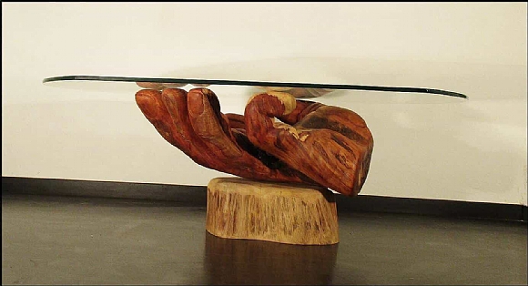 לחיצה להגדלת תמונה בסיס השולחן – כף יד ימין בעלת שש אצבעות עם הכיתוב “prepare to die”. השולחן עשוי אקליפטוס אדום על בסיס עץ מכנף נאה ומשטח זכוכית. העצים מחוברים באמצעות מוטות ברזל ודבק אפוקסי.