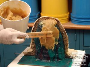 לחיצה להגדלת תמונה מערבבים ומורחים את הפוליאוריטן Plasti-Paste על תבנית הסיליקון Dragon Skin להכנת חצי מעיל התמיכה השני.