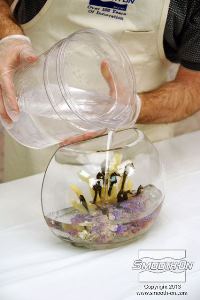 לחיצה להגדלת תמונה יוצקים את ה סיליקון שקוף לאנקפסולציה Encapso® K לתוך מיכל התצוגה. שופכים את החומר לאט ומסביב לאלמנטים בתצוגה, כדי לא להזיז אותם ממקומם.