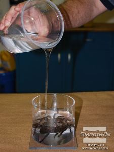 לחיצה להגדלת תמונה מודדים ומערבבים מנה נוספת של סיליקון לצרירה (לכידה) Encapso® K. שופכים לאט על הנקודה הנמוכה במיכל. מניחים לנוזל לעלות בעצמו על הטרנטולה. שופכים חומר עד שמגיעים לגובה של כ1.5 ס