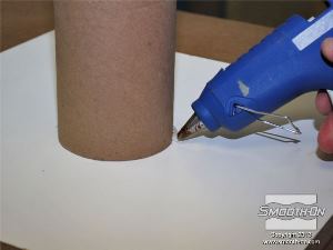 לחיצה להגדלת תמונה מדביקים את גליל הקרטון ללוח המלאמין בעזרת דבק חם.