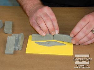 לחיצה להגדלת תמונה מניחים את רצועות החימר במיקומן הרצוי על גבי לוח הפלסטיק ולוחצים אותן כך שיחזיקו.