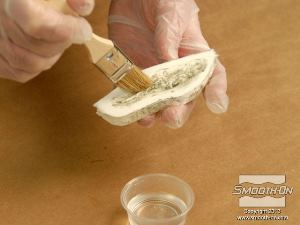 לחיצה להגדלת תמונה טובלים מברשת באלכוהול ומשתמשים בה כדי לנקות את שאריות החימר מתוך תבנית הפוליאורתן.