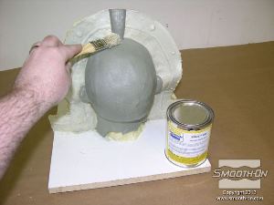 לחיצה להגדלת תמונה לאחר שספריי האקריליק התייבש מורחים חומר הפרדה על בסיס וקס Sonite Wax על הפיסול ועל קיר החימר.