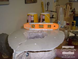 לחיצה להגדלת תמונה סוגרים את התבנית עם החימר בפנים. שמים את התבנית בתוך מיכל ומפלסים אותה.