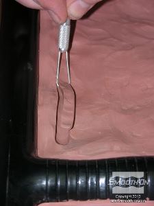 לחיצה להגדלת תמונה בעזרת כלים לפיסול חימר לפיסול יוצרים מפתחות נעילה במיטת החימר.