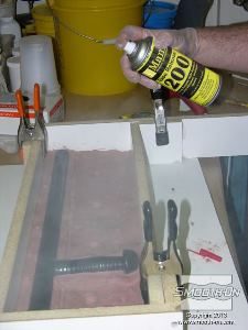 לחיצה להגדלת תמונה מרססים חומר הפרדה לתבניות סיליקון Ease-Release® 200 על המשטח שעליהם יוצקים את הגומי.