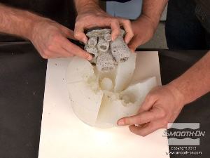 לחיצה להגדלת תמונה חולצים את המודל המקורי מהתבנית. מכיוון שהמודל המקורי מכיל אנדרקטים ופרטים עמוקים הוא נתפס בתבנית. מסיבה זו בדיוק השתמשו בסיליקון Dragon Skin®10 להכנת התבנית כי חומר זה הוא גמיש וחזק ויוכל לעמוד בחליצת המודל.