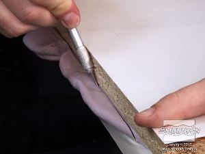 לחיצה להגדלת תמונה חותכים בסכין חד את עודף בצק הסיליקון Equinox® 40 שיוצא מקצוות הלוחות.