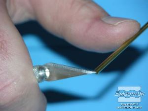 לחיצה להגדלת תמונה מחדדים קצה של צינור פליז בעזרת סכין.