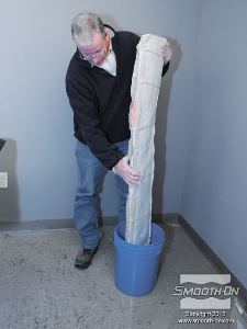 לחיצה להגדלת תמונה ממקמים את התבנית בתוך דלי ומניחים חפצים מסביבה כך שתשאר זקופה בזמן היציקה.