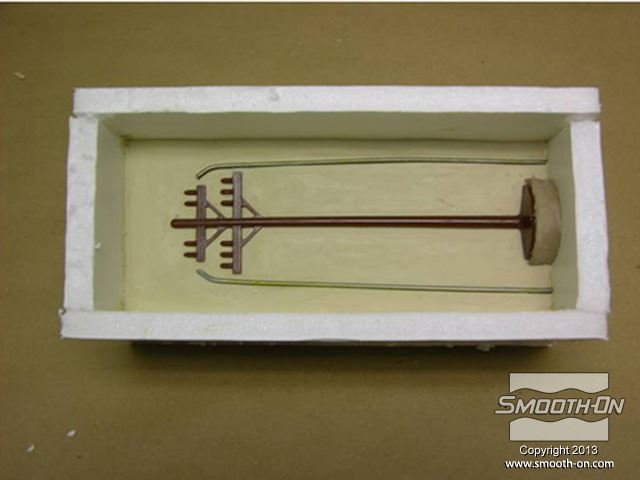 מטביעים עמוד טלפון מיניאטורי (עד לאמצע שלו) בתוך חימר נטול גופרית LBT/NSP  (בתוך קופסת תבנית).