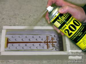 לחיצה להגדלת תמונה מרססים חומר הפרדה לסיליקון  Ease Release® 200 על משטח הסיליקון החשוף. ספריי הפרדה לסיליקון  Ease Release® 200 דואג שהסיליקון הנוזלי לא ידבק לסיליקון המוצק.