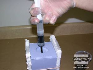 לחיצה להגדלת תמונה מזריקים את שרף הSmooth-Cast® 320, בעל הצמיגות הנמוכה, אל התבנית.