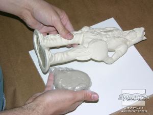 לחיצה להגדלת תמונה ממקמים את החתיכת החימר העטופה בפלסטיק מאחורי המודל ולצידו.