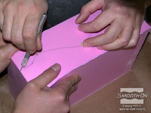 לחיצה להגדלת תמונה חליצת המודל: קו הסימון שצוייר על לוח הבסיס עבר לתבנית וכעת ניתן לבצע חתך בתבנית לאורכו. מומלץ להשתמש בעזרת אדם נוסף שיפריד את שני צידי התבנית בזמן ביצוע החתך.