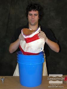 לחיצה להגדלת תמונה מכניסים את תבנית הBody Double למעיל הגבס. מדביקים את שני חצאי המעיל ולאחר מכן מקבעים אותו בתוך דלי כדי שיהיה נוח יותר לעבוד עם התבנית בזמן היציקה.